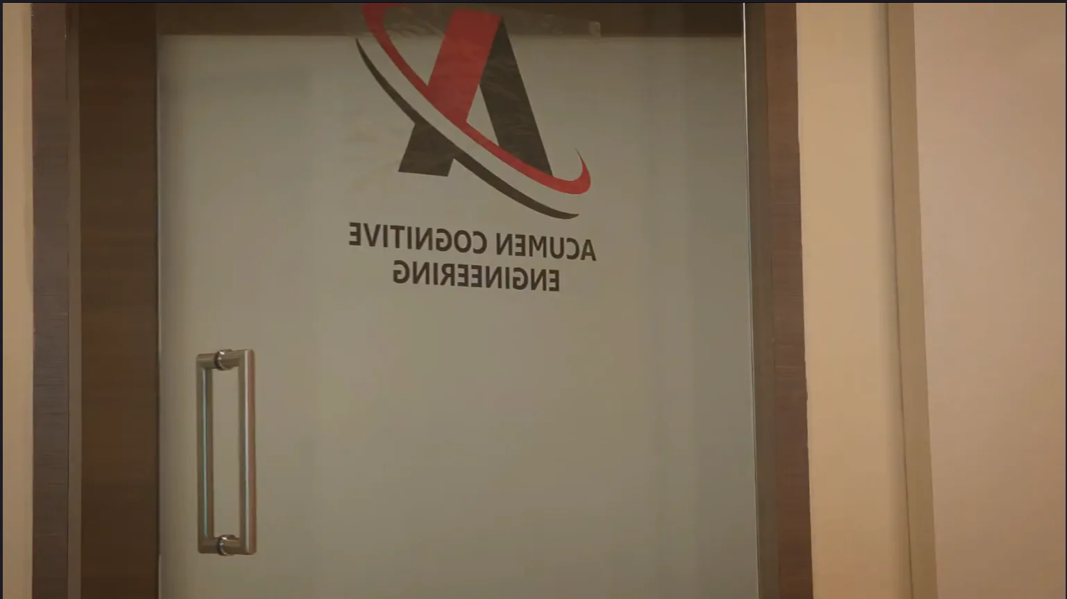 The glass door at Acumen’s office bearing the Acumen Cognitive Engineering logo and name.